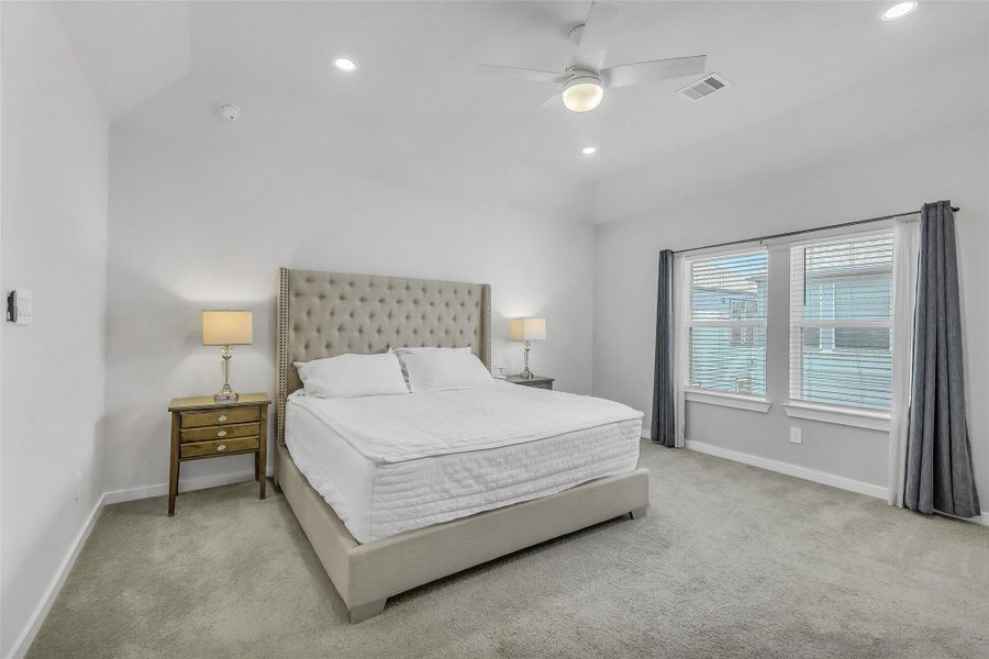 Spacious primary suite featuring large windows, abundant natural light, and a relaxing atmosphere designed to feel like a private retreat.