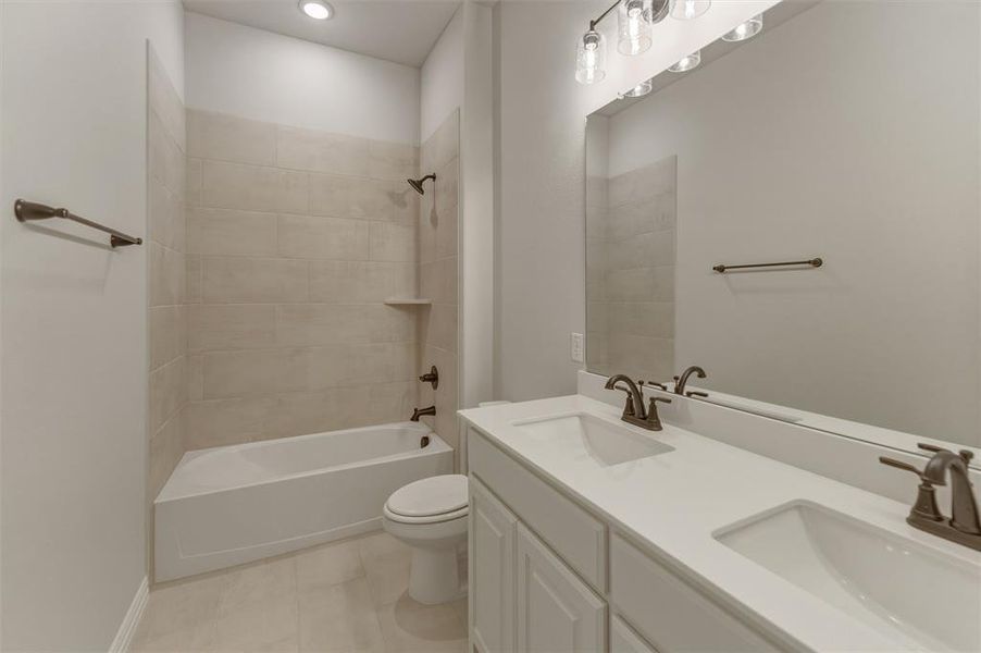 Bathroom featuring a white dual vanity with undermount sinks and bronze-finish faucets Bathroom featuring a white dual vanity with undermount sinks and bronze-finish faucets