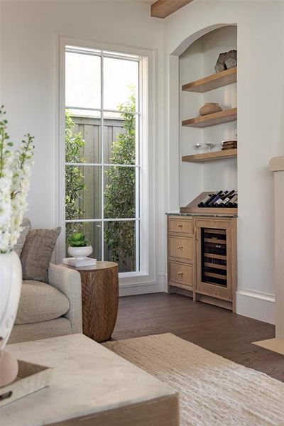 Living area with built in features, dark wood-style floors, and beverage cooler Living area with built in features, dark wood-style floors, and beverage cooler