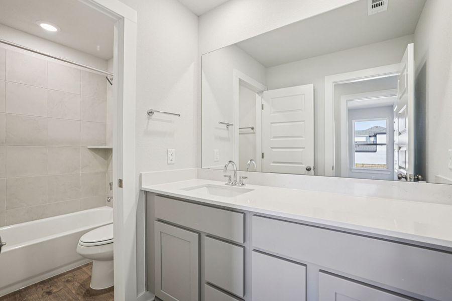 A bathroom with a tub sink and toilet.