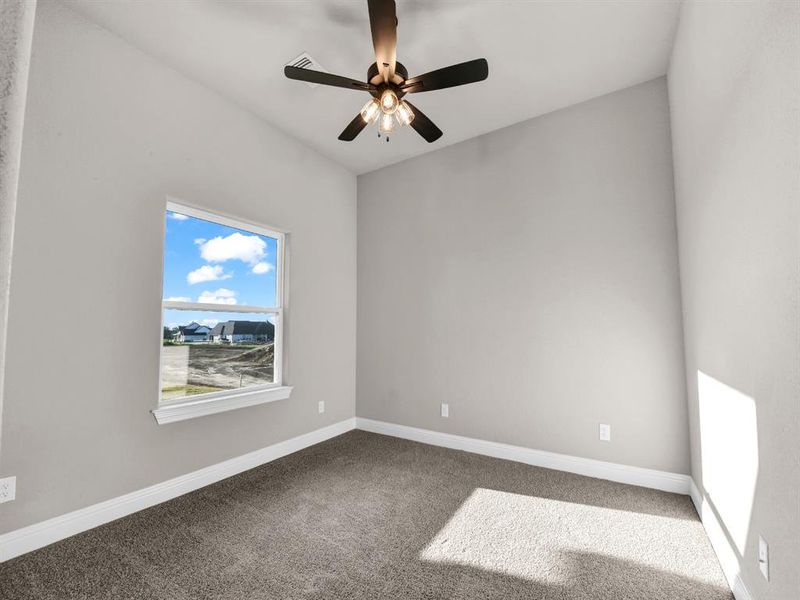 Carpeted spare room with ceiling fan