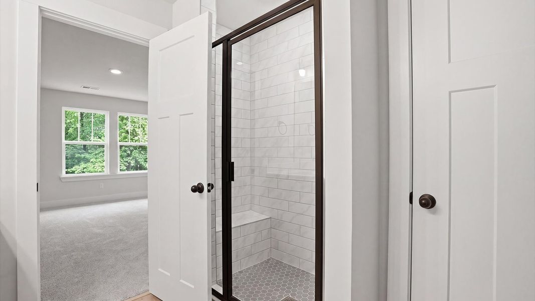 Memorable mornings begin in this elegant primary bathroom with walk-in shower and black fixtures located at Anna's Pointe