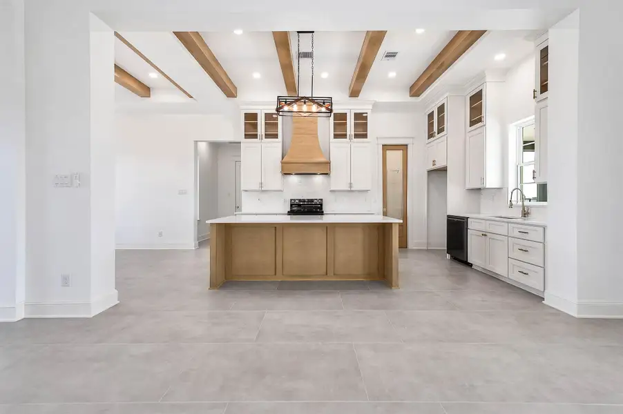 Open-concept kitchen and living area with a large island, warm wood accents, and plenty of room for everyday living and entertaining.