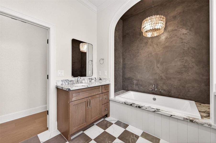 Micro cement finish around the bathtub with a beautiful chandelier to complete this elegant look.