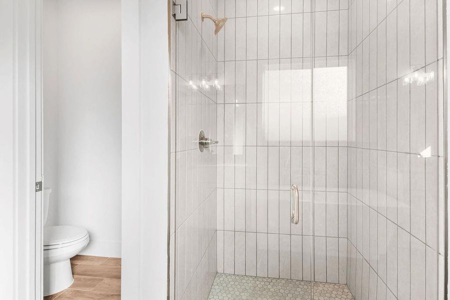 A sleek, contemporary shower enclosure boasts pristine white tiling and a clear glass door. A sleek, contemporary shower enclosure boasts pristine white tiling and a clear glass door.