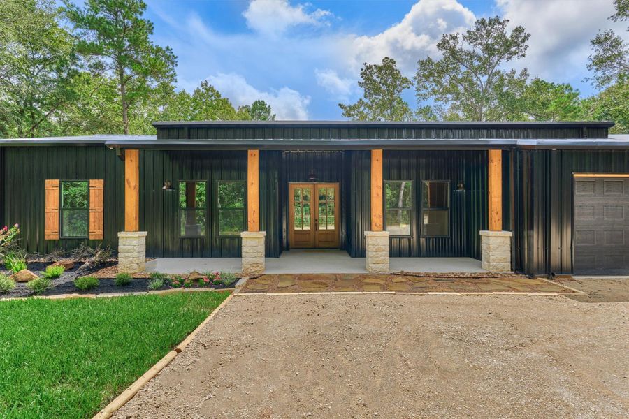 The stone and wood beam columns make a bold statement at the entryway and highlight the glass paneled front door and porch