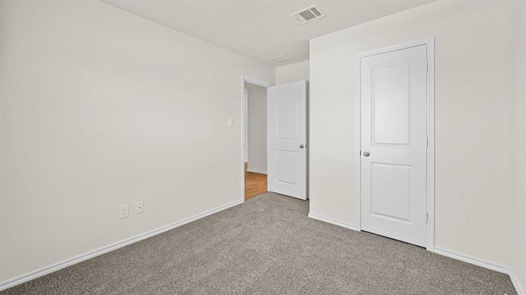 Unfurnished bedroom with carpet floors and baseboards