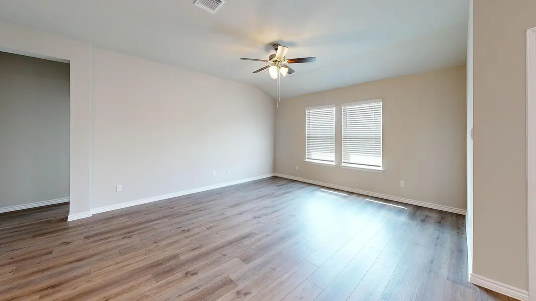 Empty room with ceiling fan, light wood finished floors, and lofted ceiling