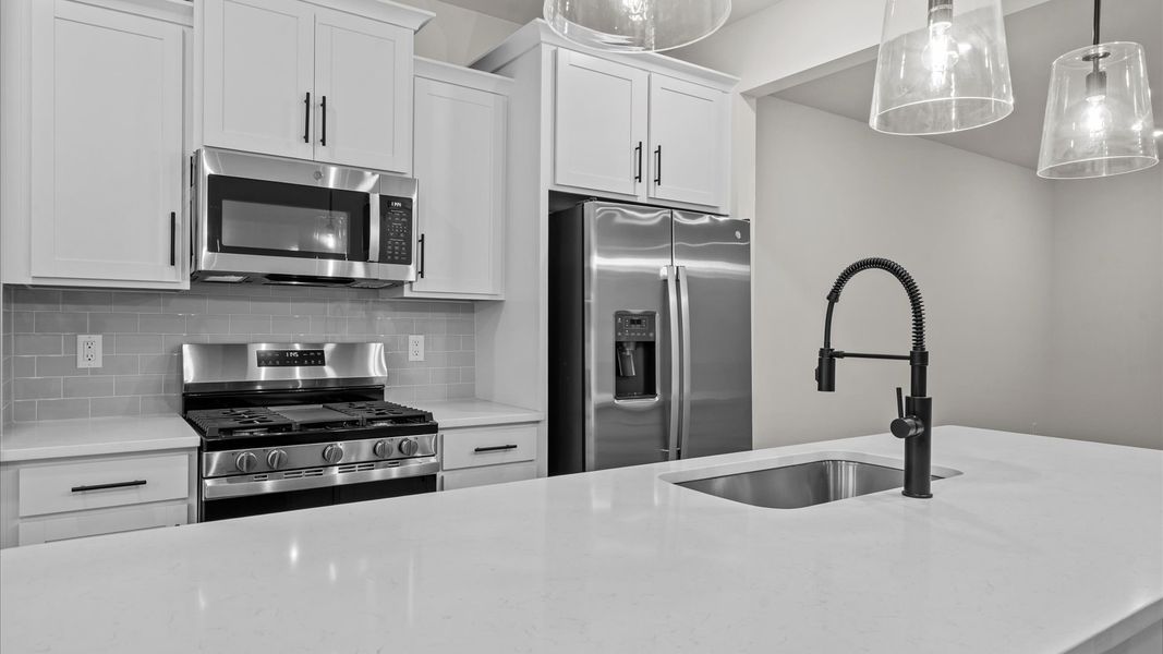 Exclusive DRB Homes kitchen with a 9-foot island, elevated finishes, and pendant lighting in a prime location