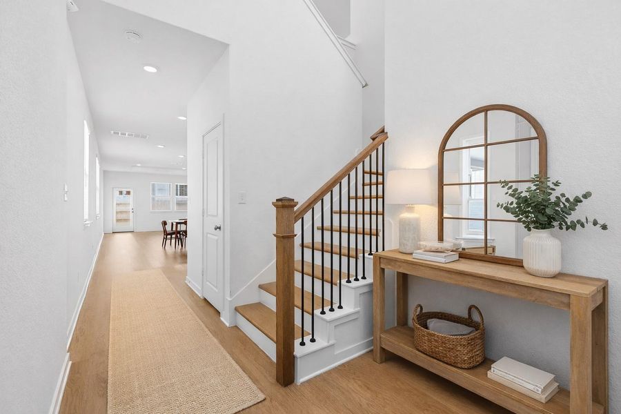 Stairway with wood finished floors and recessed lighting