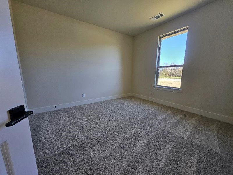 Carpeted empty room featuring baseboards