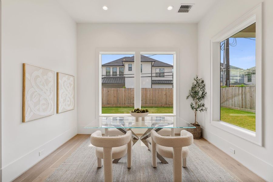 A dedicated breakfast area sits just off the kitchen, surrounded by large windows that bring in abundant natural light and provide views of the backyard.