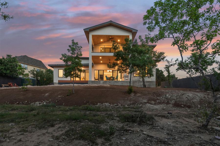 Photo similar to home being built. Rear view of house with stucco siding and a balcony