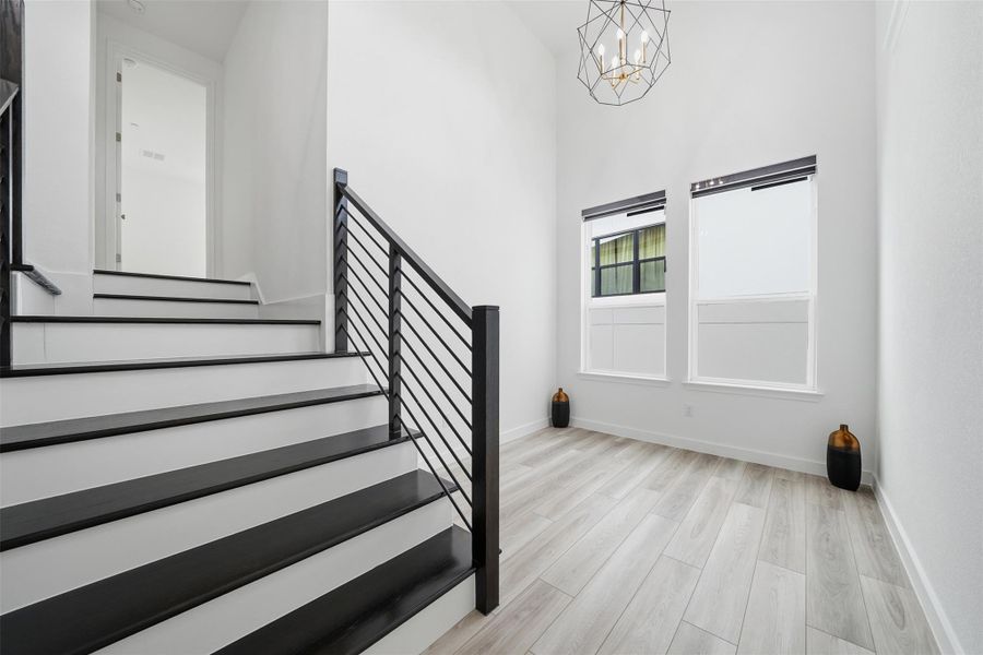 The property features a staircase with black treads and white risers, complemented by a black metal railing