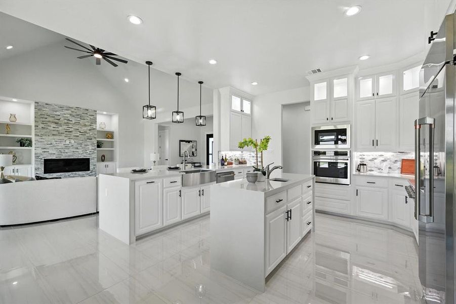 Kitchen with open floor plan, appliances with stainless steel finishes, a peninsula, light countertops, and white cabinets Kitchen with open floor plan, appliances with stainless steel finishes, a peninsula, light countertops, and white cabinets