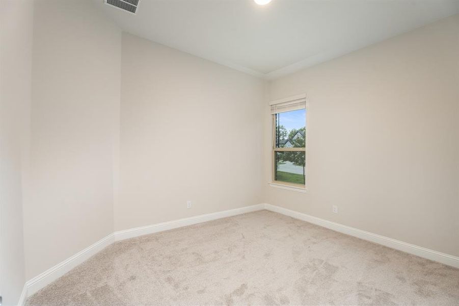 Empty room featuring light colored carpet and baseboards