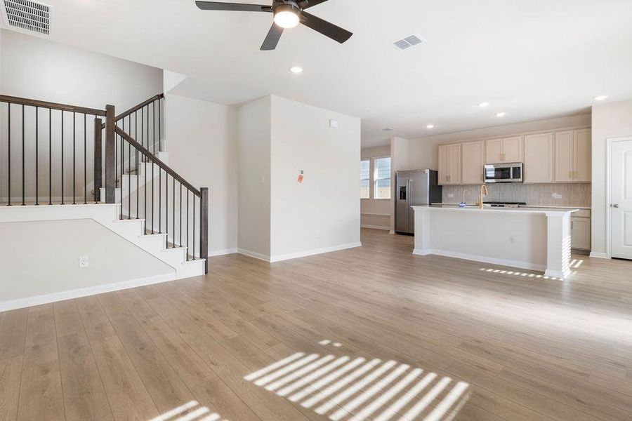 Unfurnished living room with light wood-style floors, a ceiling fan, and recessed lighting