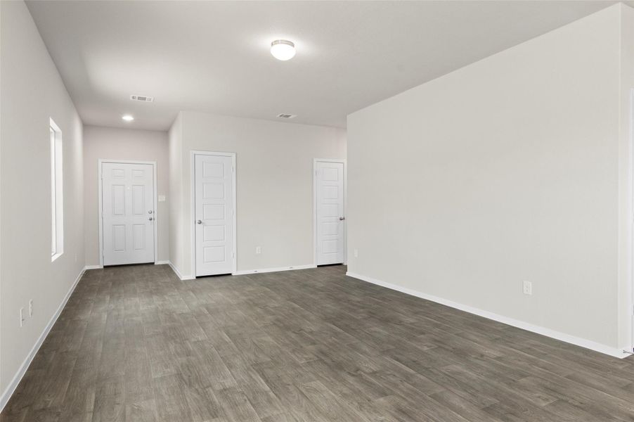 Empty room with dark wood-style flooring and recessed lighting Empty room with dark wood-style flooring and recessed lighting