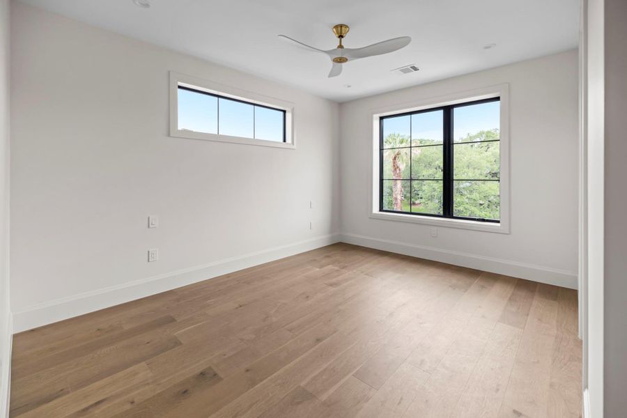 Unfurnished room featuring baseboards, light wood finished floors, and ceiling fan