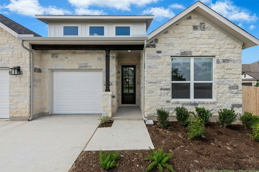 A striking stone facade with clean lines and contemporary windows presents welcoming curb appeal.