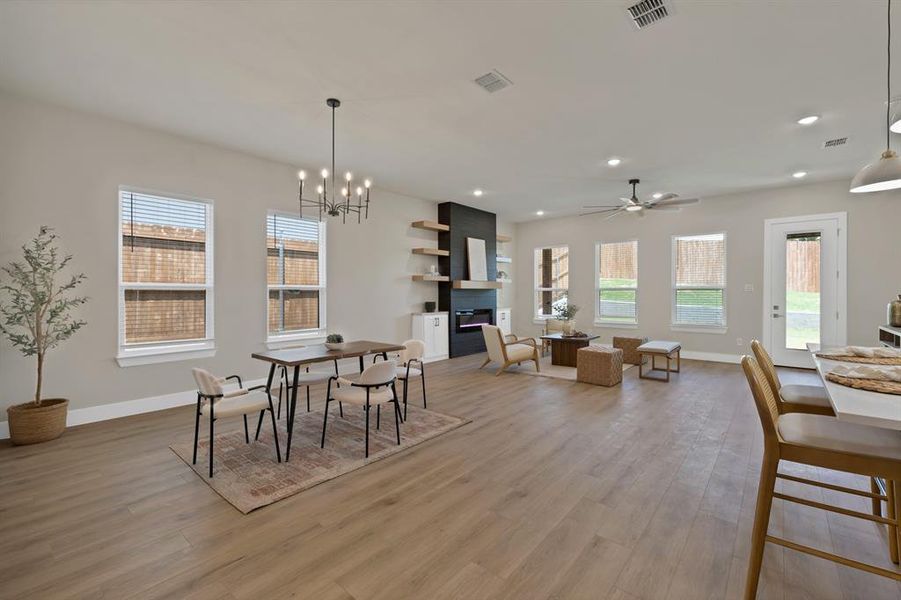 Dining room featuring light wood-type flooring, baseboards, recessed lighting, a chandelier, and a ceiling fan Dining room featuring light wood-type flooring, baseboards, recessed lighting, a chandelier, and a ceiling fan