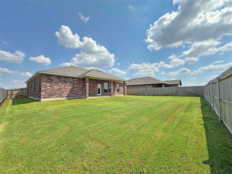Rear view of property with a patio, a fenced backyard, and brick siding Rear view of property with a patio, a fenced backyard, and brick siding