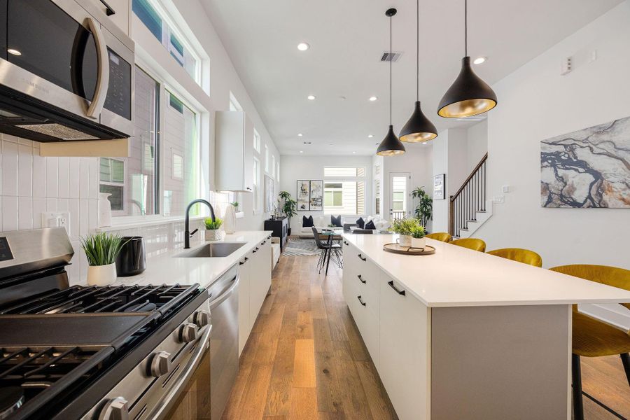 Another view of the kitchen equipped with gas range, under-cabinet lighting, an oversized sink, and other elegant finishes.