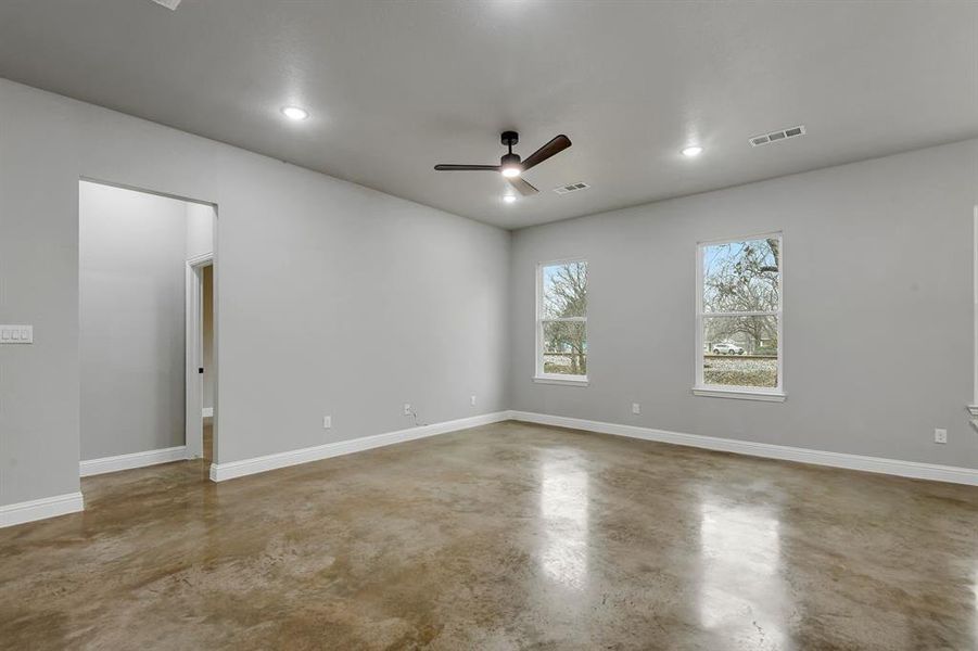 Empty room with finished concrete flooring, ceiling fan, and recessed lighting