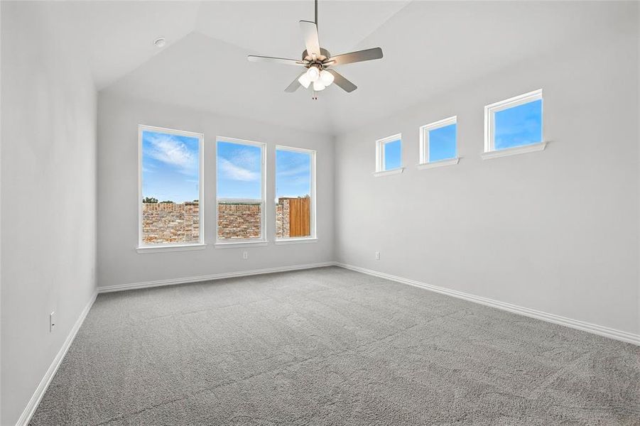 Carpeted spare room featuring ceiling fan and vaulted ceiling Carpeted spare room featuring ceiling fan and vaulted ceiling