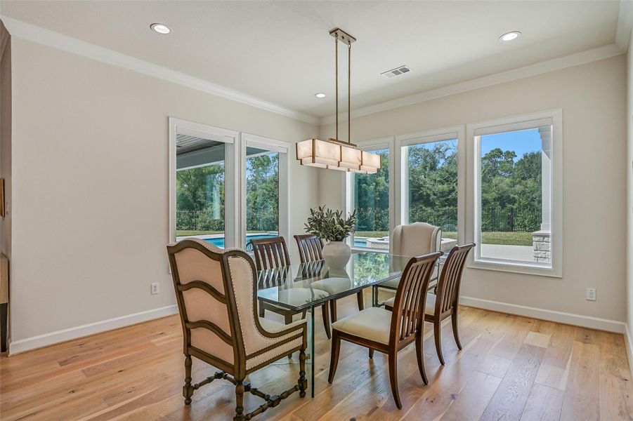 The adjoining breakfast room is wrapped in oversized windows overlooking the pool & backyard, creating a light-filled dining space just steps from the kitchen and covered outdoor living area.