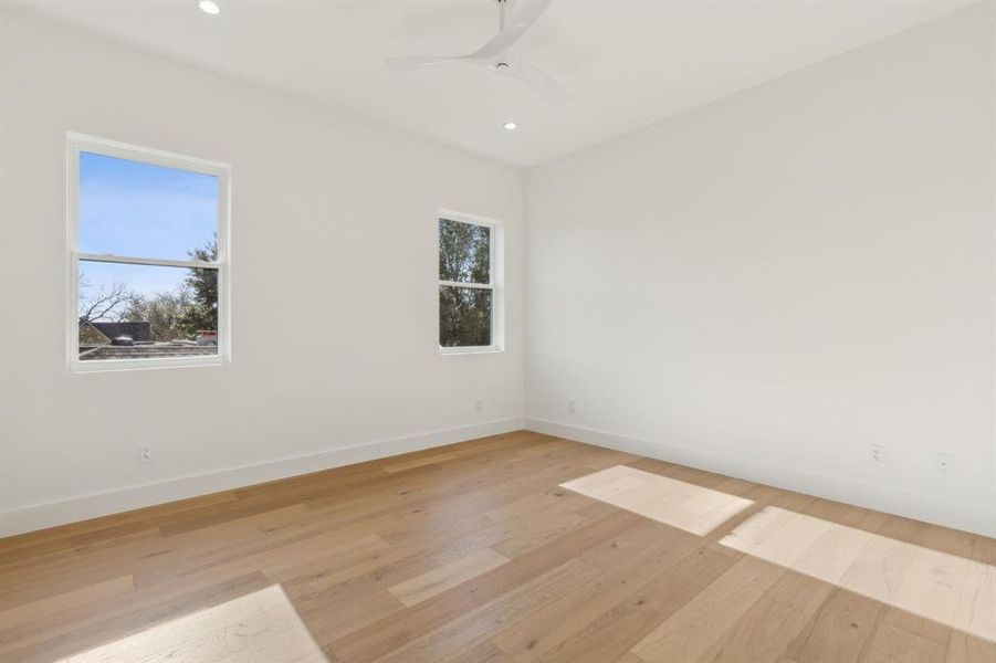 Empty room featuring ceiling fan, plenty of natural light, and light wood-type flooring