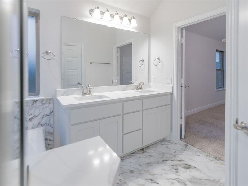 Bathroom with vanity and lofted ceiling