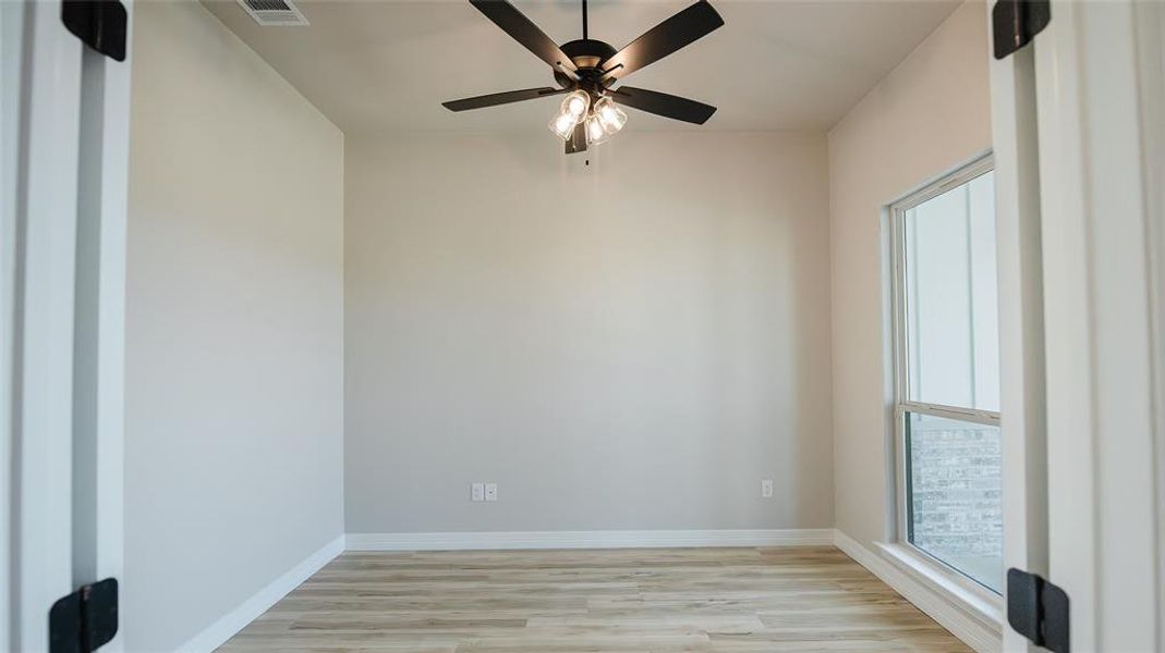 Empty room with plenty of natural light, light wood-type flooring, and ceiling fan Empty room with plenty of natural light, light wood-type flooring, and ceiling fan