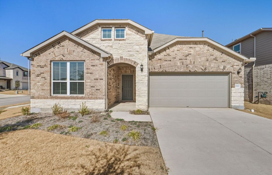 Front exterior of a new home in Lagos, Manor, TX, highlighting curb appeal (Image 23).