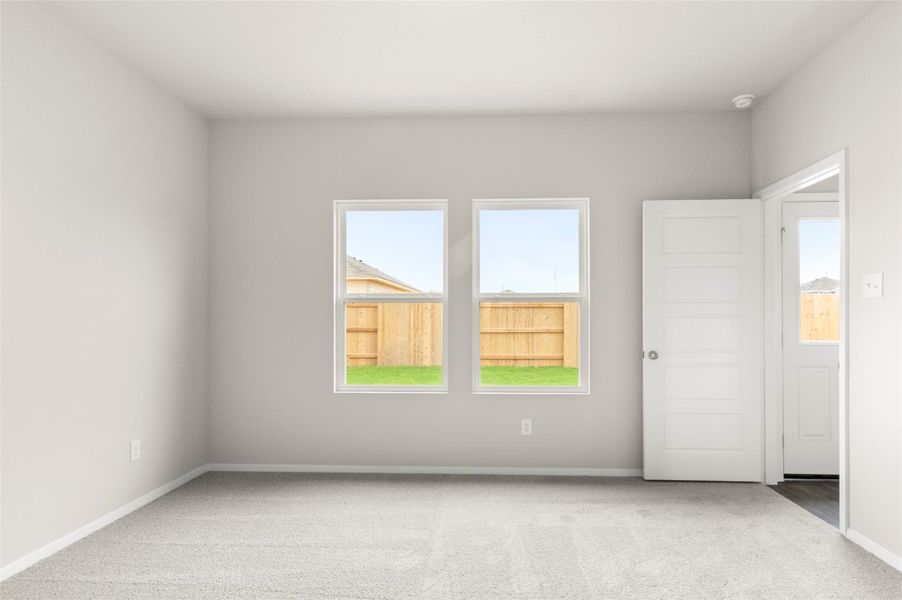 Unfurnished room with light colored carpet and healthy amount of natural light