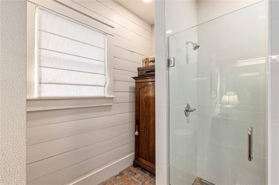 Glass-enclosed shower with chrome fixtures, white subway tile surround, and recessed lighting