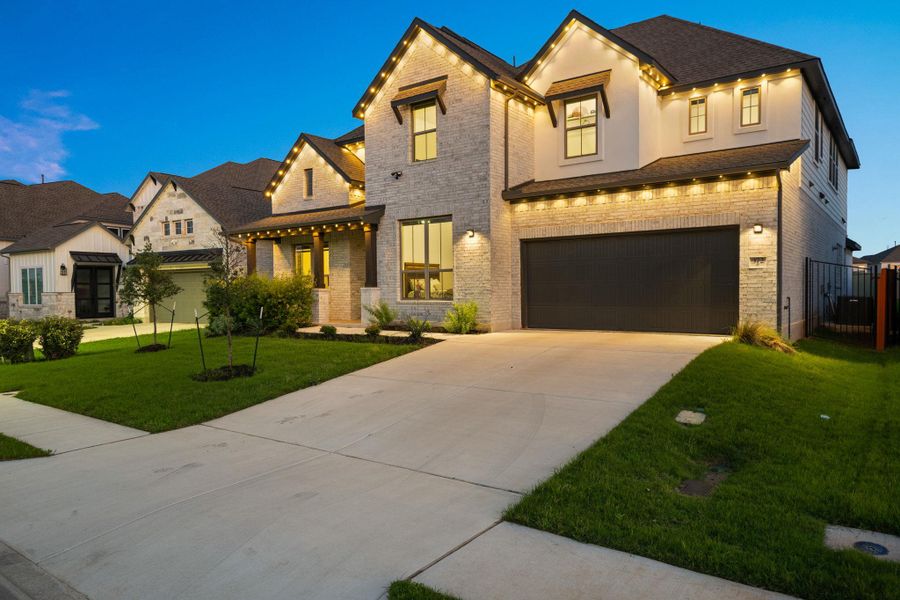Illuminated by evening lights, this residence showcases a spacious attached garage and meticulously kept landscaping. Illuminated by evening lights, this residence showcases a spacious attached garage and meticulously kept landscaping.