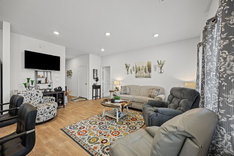 Living area featuring light wood-style flooring and recessed lighting
