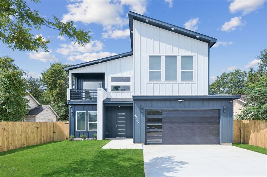 View of front of home with board and batten siding, a balcony, a garage, and driveway