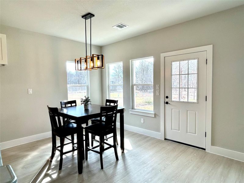 Dining area with light wood-type flooring and a chandelier