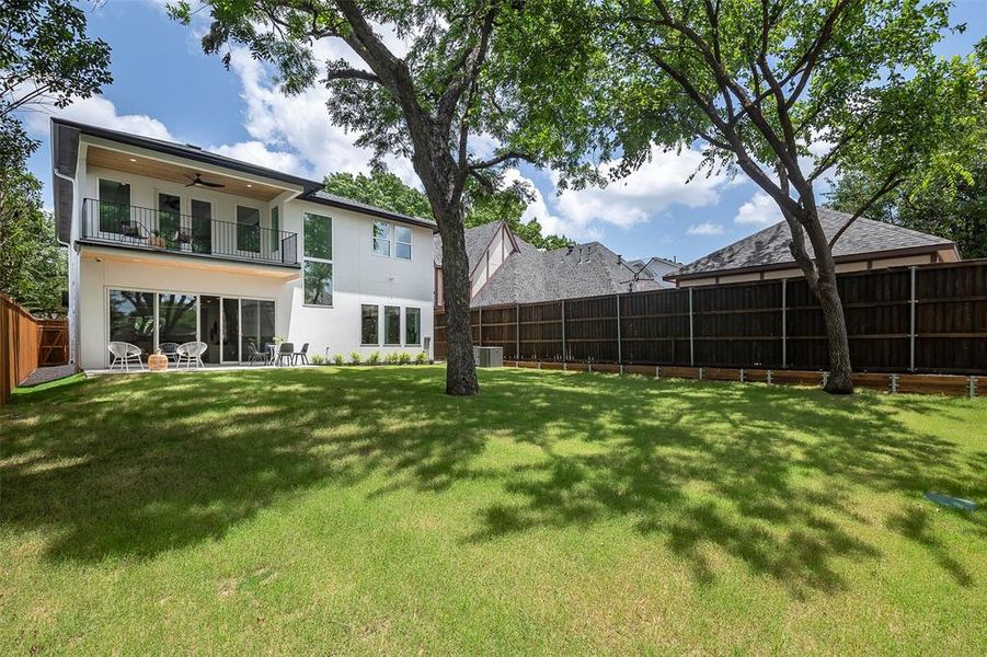 View of yard featuring a balcony and ceiling fan