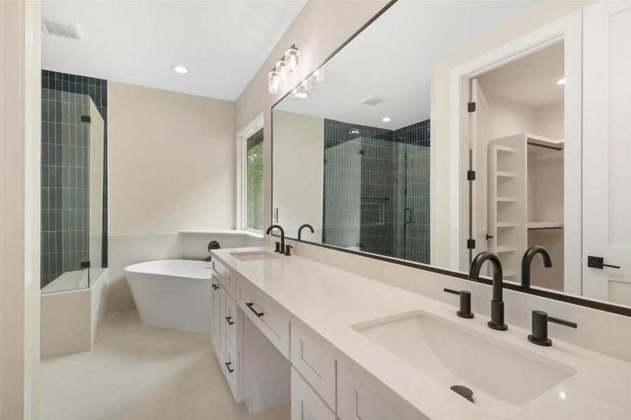Bathroom with a freestanding tub, a sink, a shower stall, and visible vents Bathroom with a freestanding tub, a sink, a shower stall, and visible vents