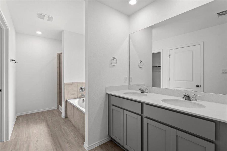 A well-appointed bath boasts dual vanities and a relaxing soaking tub. A well-appointed bath boasts dual vanities and a relaxing soaking tub.