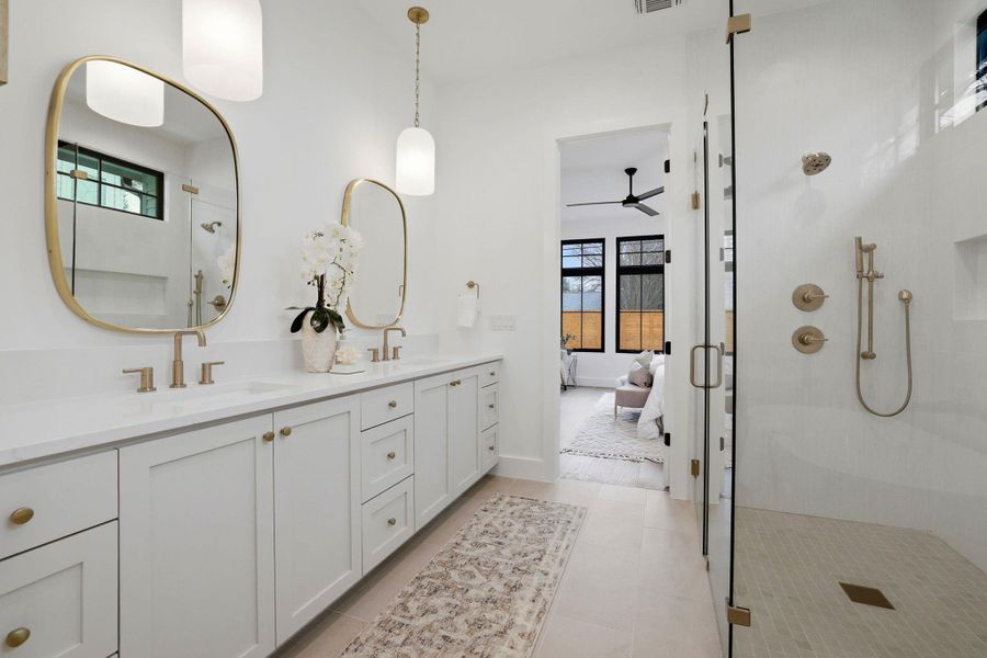 Full bathroom featuring ensuite bathroom, a stall shower, double vanity, and a ceiling fan