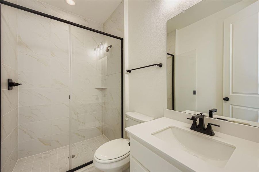 Bathroom with vanity and a marble finish shower