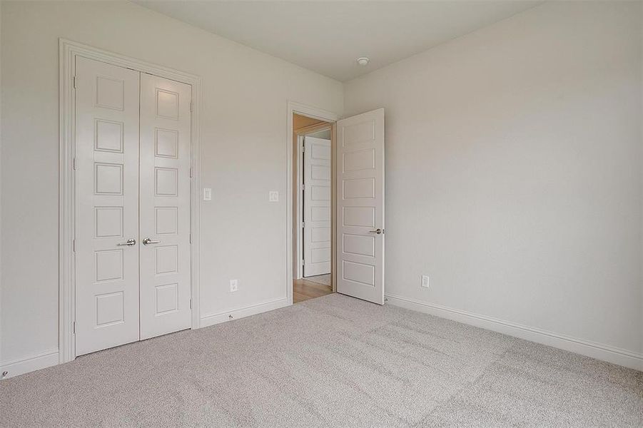 Unfurnished bedroom with a closet and light colored carpet