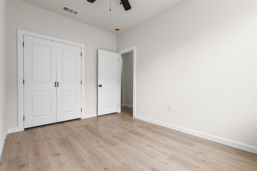 Room featuring wood-finish flooring, crisp white baseboards, and a neutral wall palette