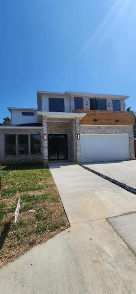 View of front of home with driveway, brick siding, and a garage View of front of home with driveway, brick siding, and a garage