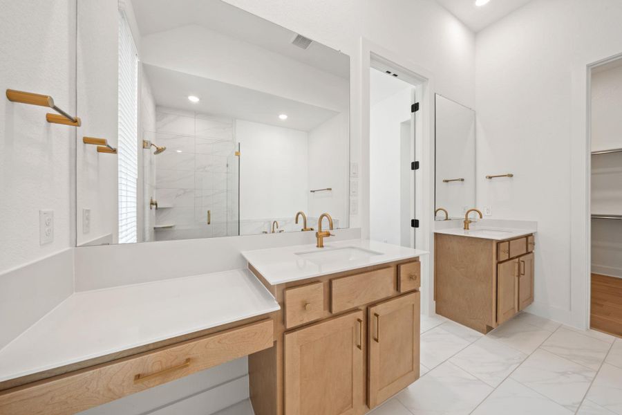 Bathroom with a shower stall, two vanities, light marble finish floors, a walk in closet, and recessed lighting