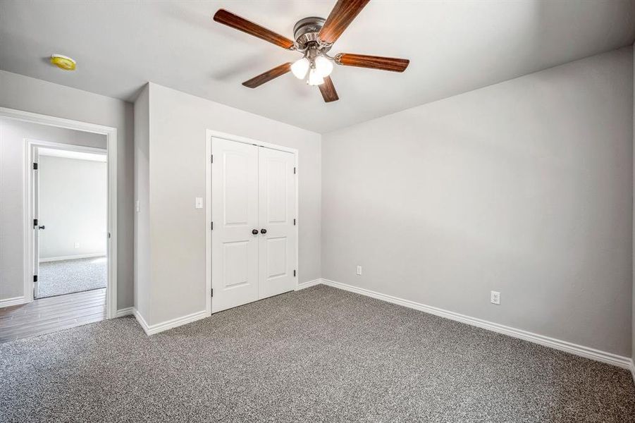 Bedroom 3 with carpet floors, ceiling fan, and a closet